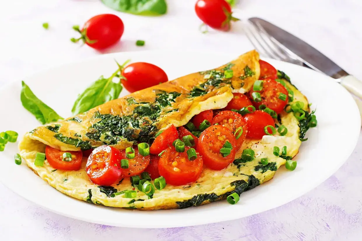 Omelette aux épinards et tomates cerises, un plat sain et savoureux pour un régime alimentaire perte de poids réussi.