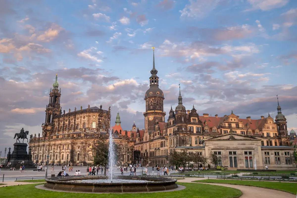 Piękny widok na zamek i kościół w Dreźnie, z fontanną i ludźmi spacerującymi po placu.