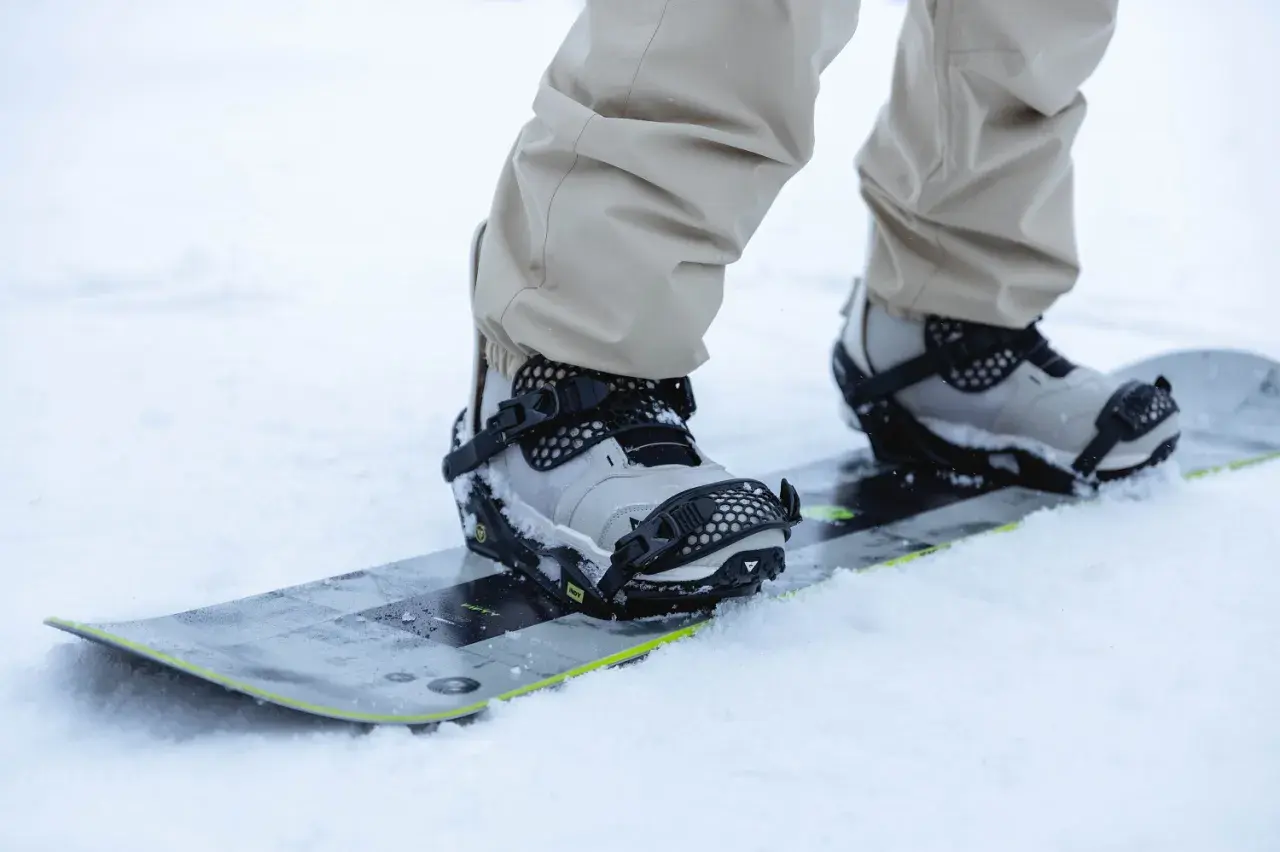 Zbliżenie na buty snowboardowe w wiązaniach. Dowiedz się, jak ustawić wiązania snowboard, by cieszyć się jazdą.