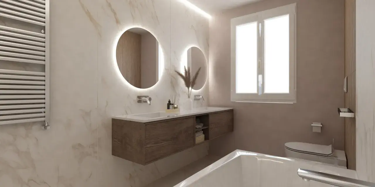 Bagni eleganti con pareti in marmo, doppio lavabo con specchi rotondi illuminati, mobile sospeso in legno e vasca da bagno.