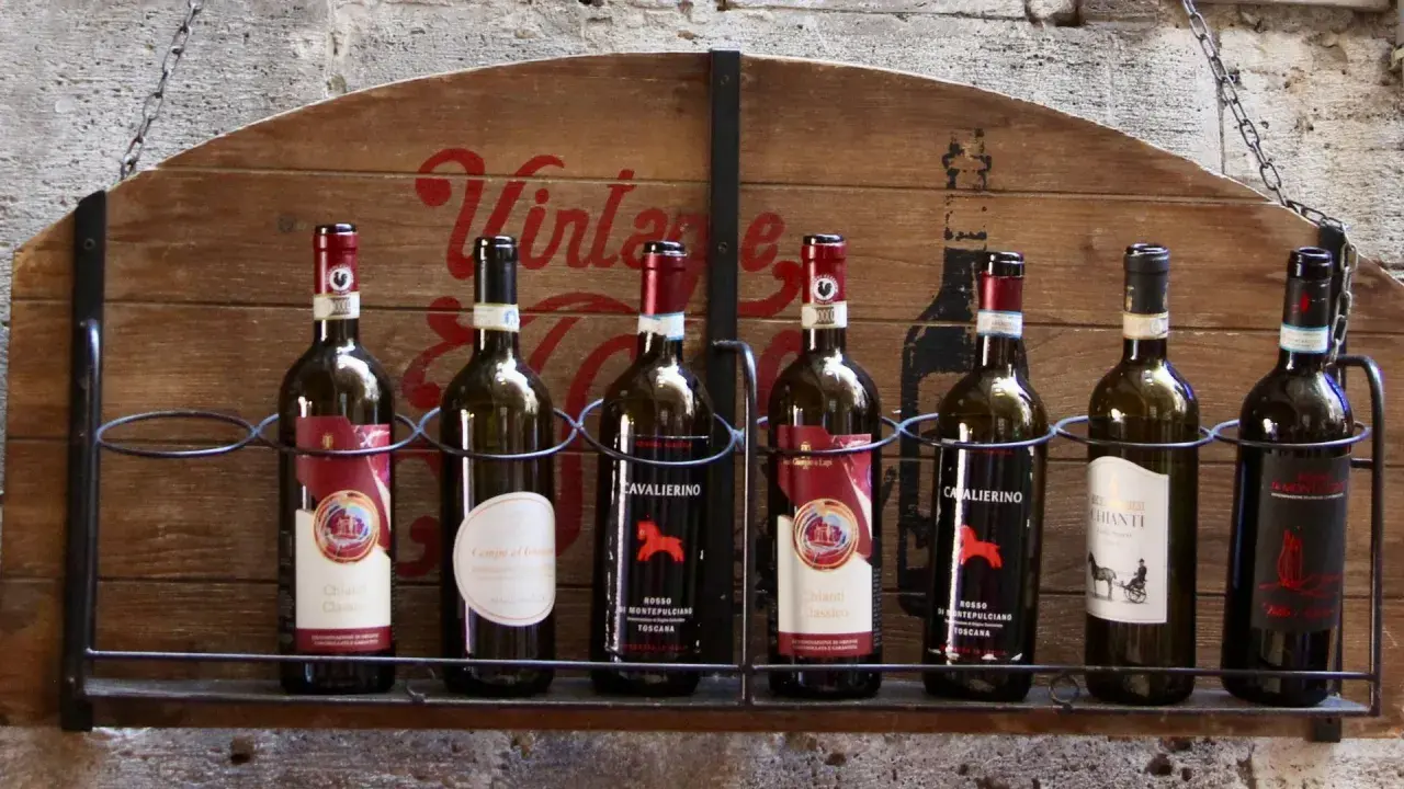 Eine Auswahl der besten Weine der Toskana, präsentiert auf einem rustikalen Holzschild.