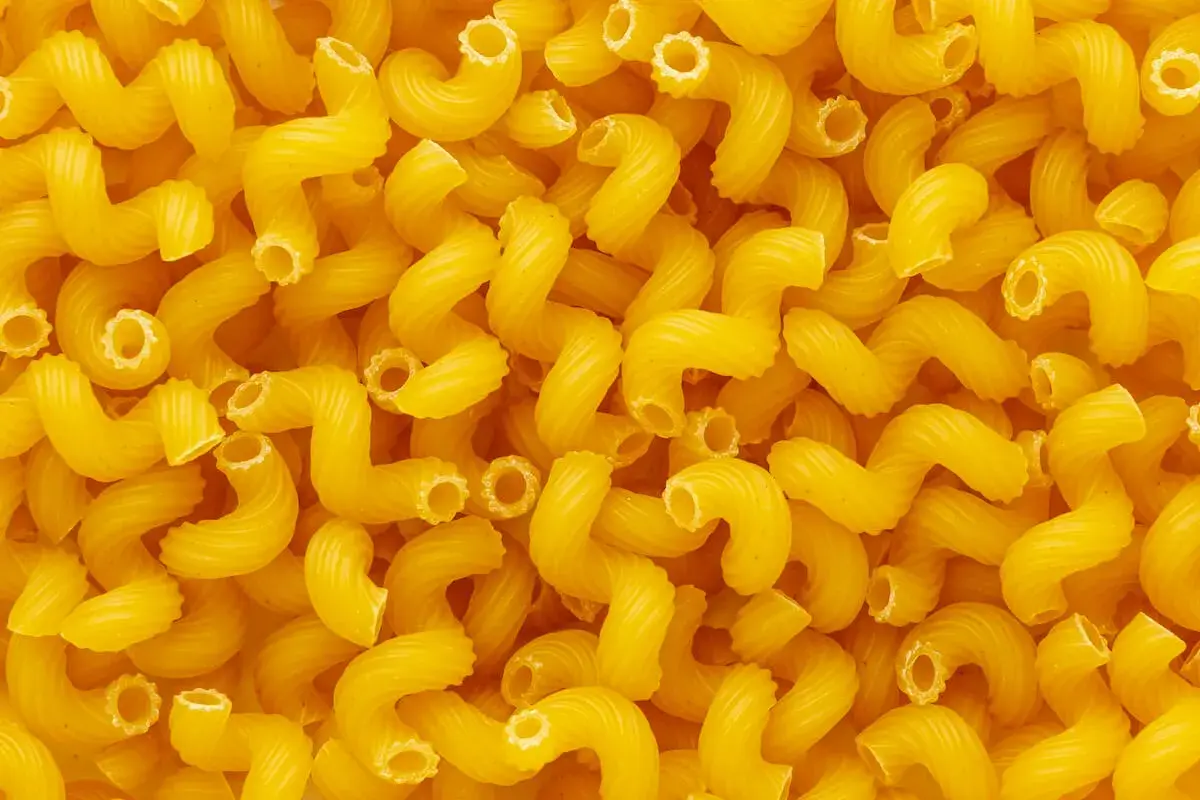 Góra żółtego makaronu cavatappi. Zastanawiasz się, ile białka ma makaron?