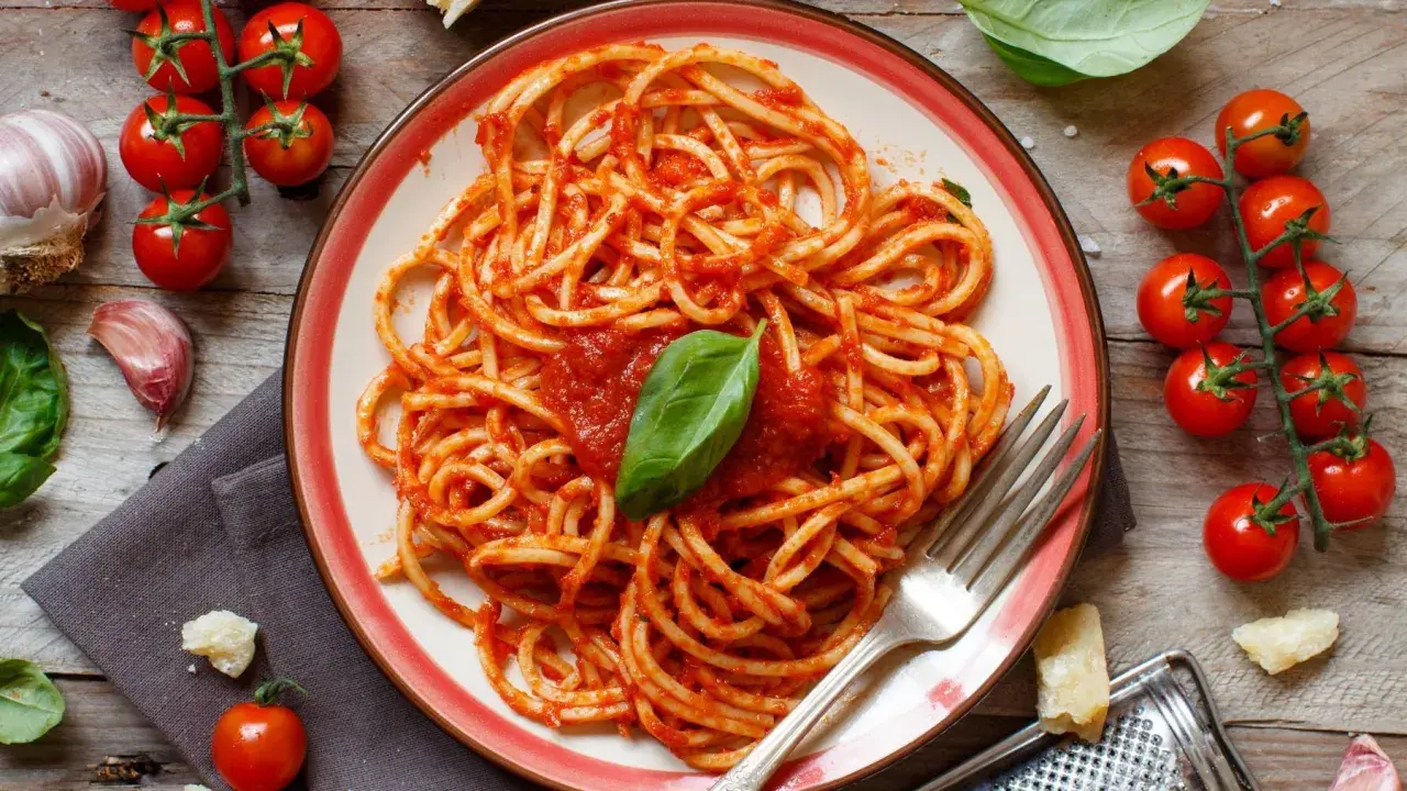 Pyszne spaghetti z sosem pomidorowym, czosnkiem i bazylią. Idealne danie, by pokazać, co zrobić z pomidorów na obiad.