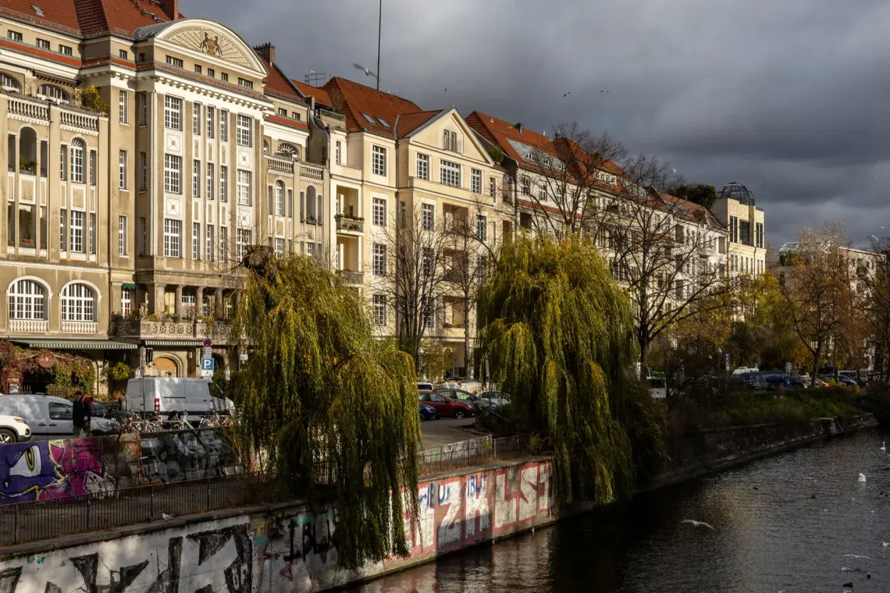 Berliner Altbauten am Wasser, mit Weiden und Graffiti. Hier gibt es viele Berlin Insider Tipps zu entdecken.