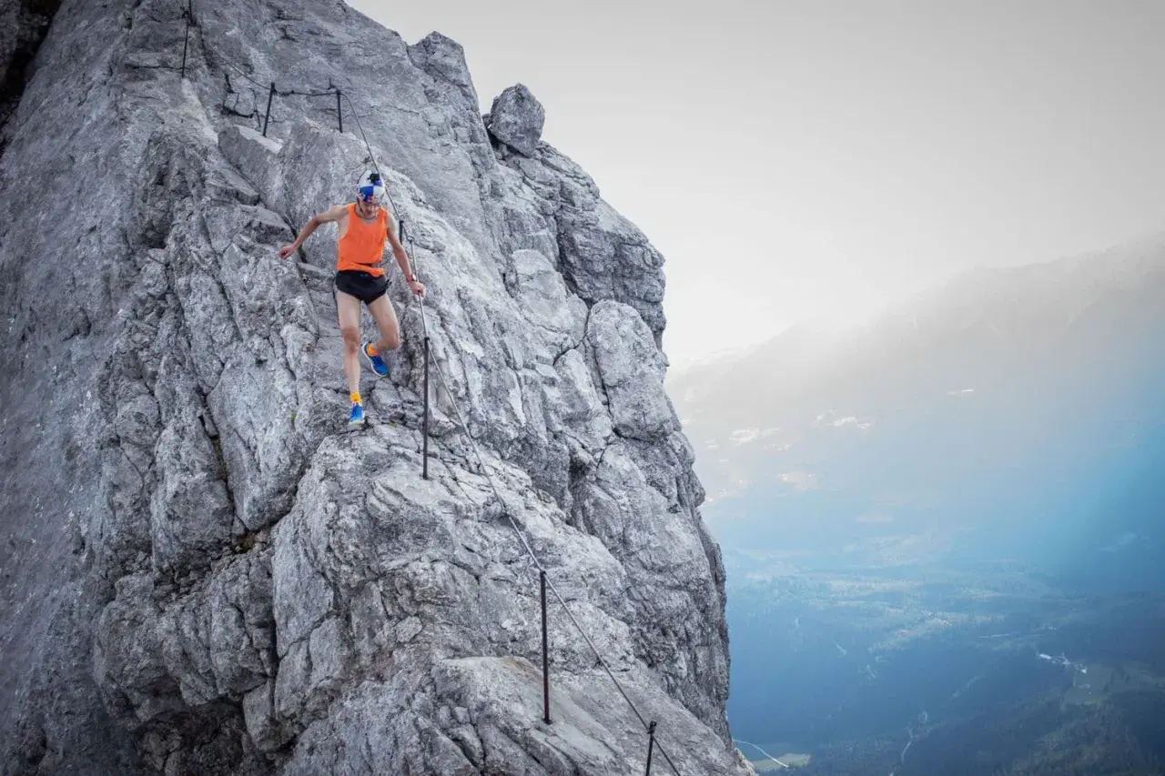 Anton Palzer bezwingt den Watzmann, ein Trailrunner in Aktion auf steilem Fels mit Sicherungsseil.