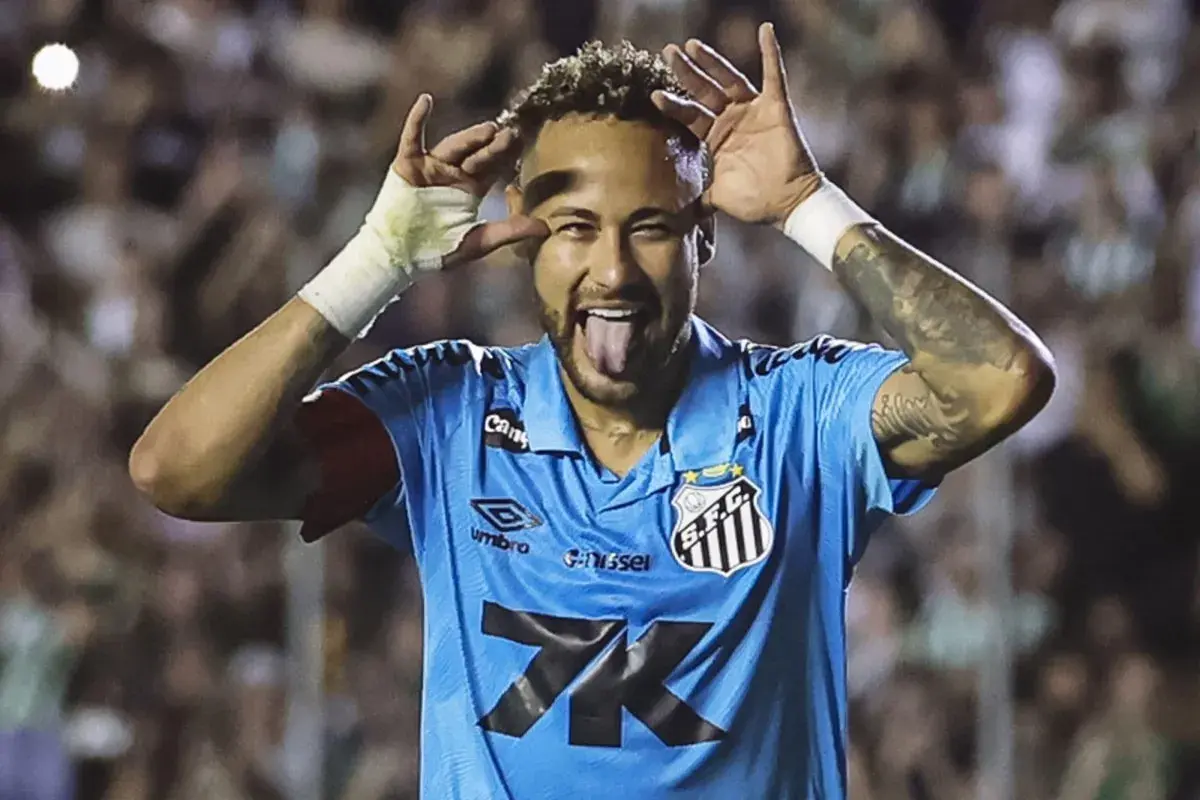 Neymar, w niebieskiej koszulce Santos, z językiem na wierzchu i rękami przy oczach, świętuje bramkę. Czy to zapowiedź jego kolejnego transferu?