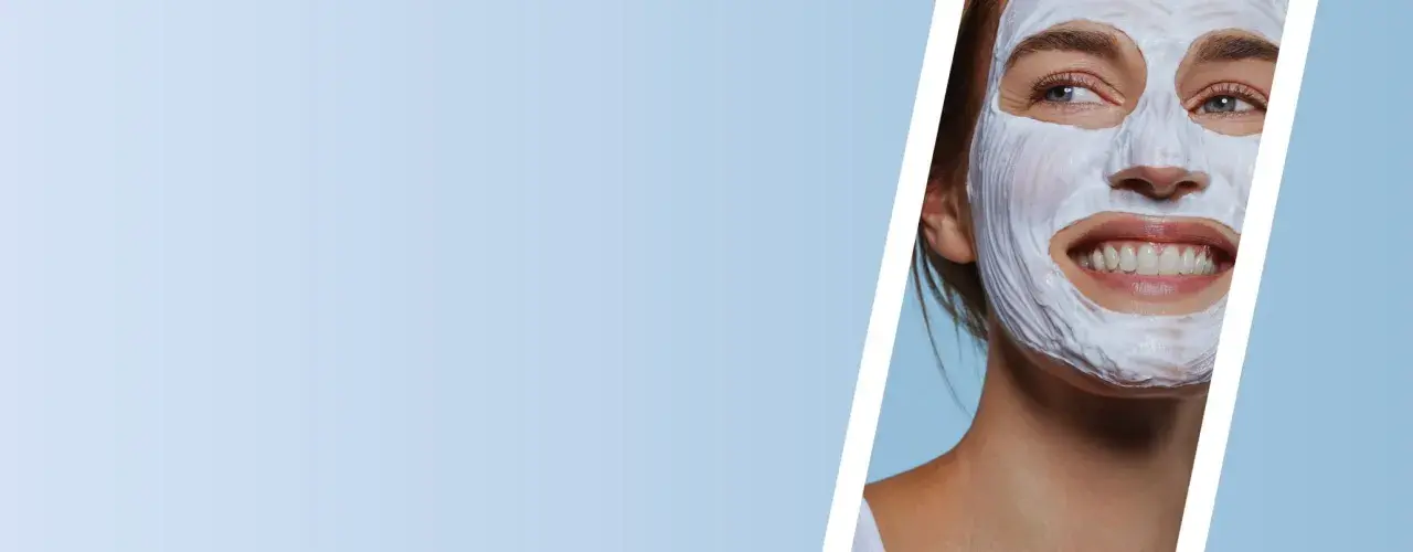Mujer sonriente con mascarilla de arcilla blanca, disfrutando de un momento de cuidado facial.
