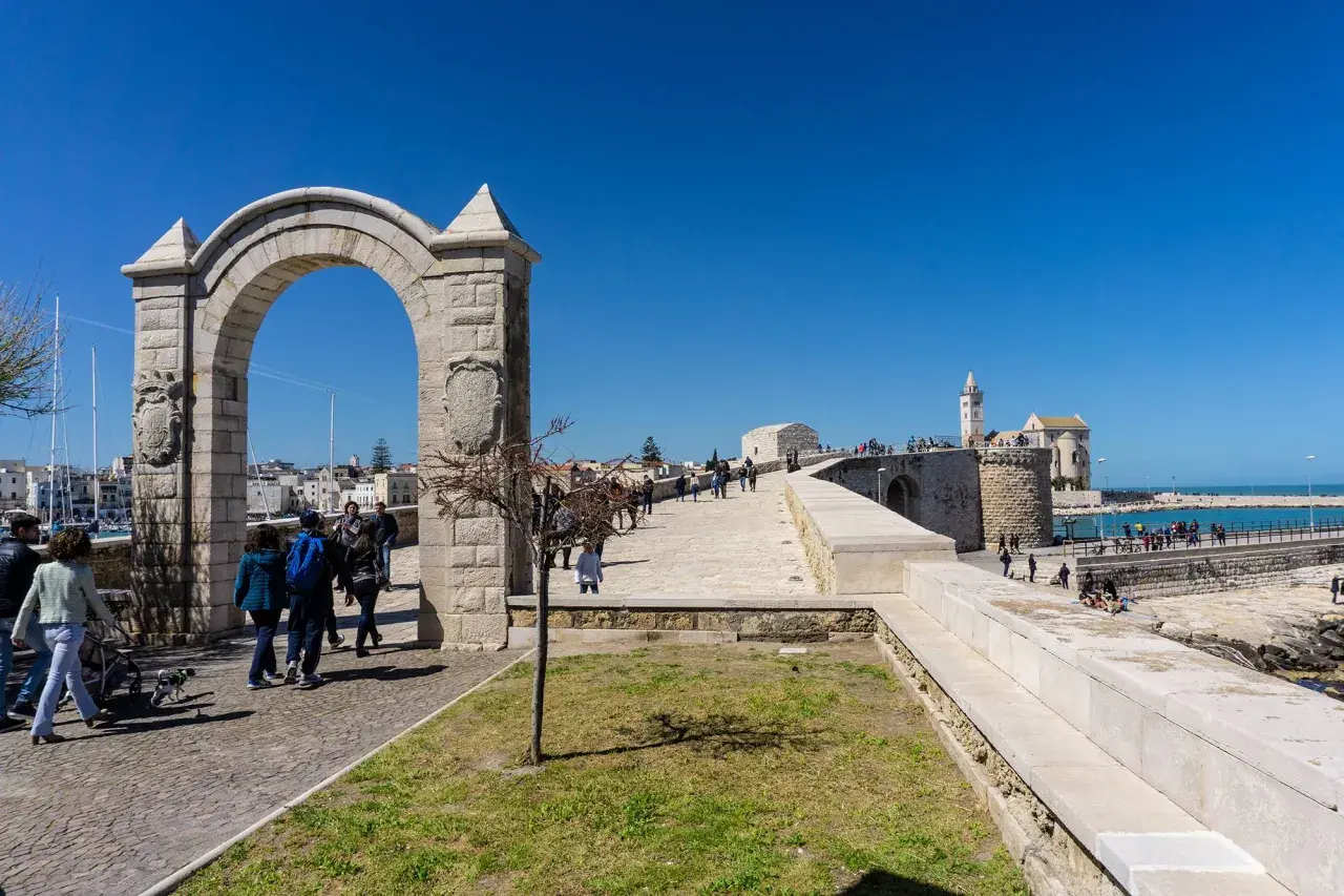 Arco monumentale e passeggiata sul lungomare, con la cattedrale in lontananza. Ecco cosa vedere a Trani.