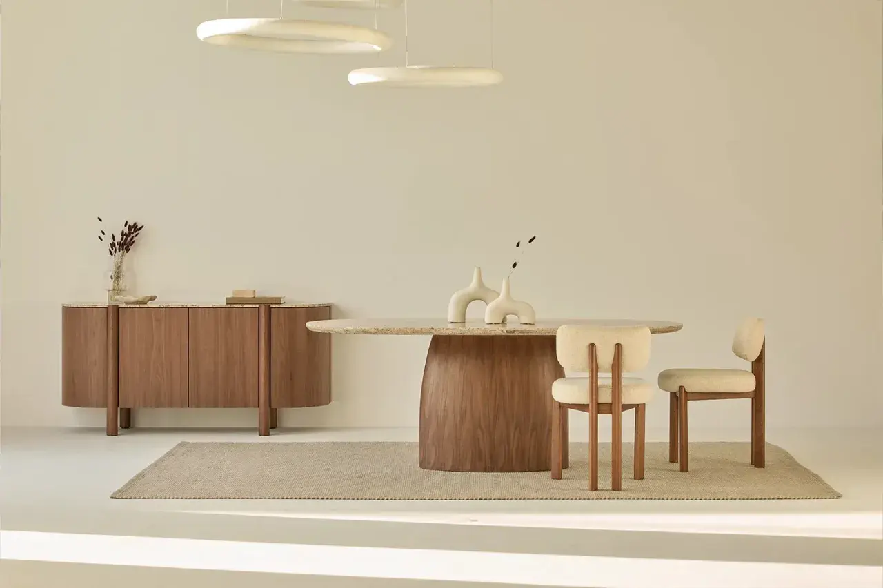 Comedor moderno con mesa ovalada, sillas tapizadas y aparador de madera. Tres lámparas con **aro led techo** iluminan el espacio.