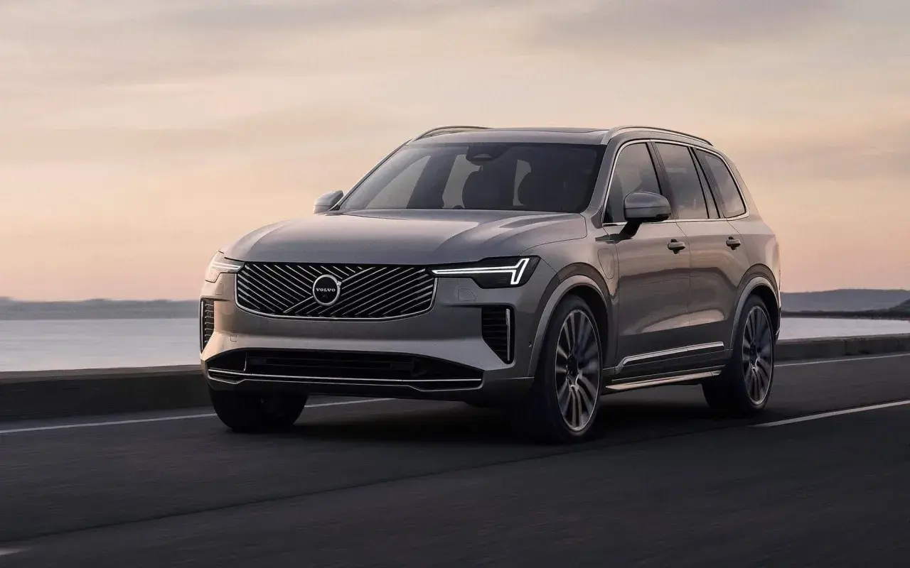 Szary Volvo XC90 jedzie po drodze nad morzem. Sprawdź aktualną volvo xc90 cena.
