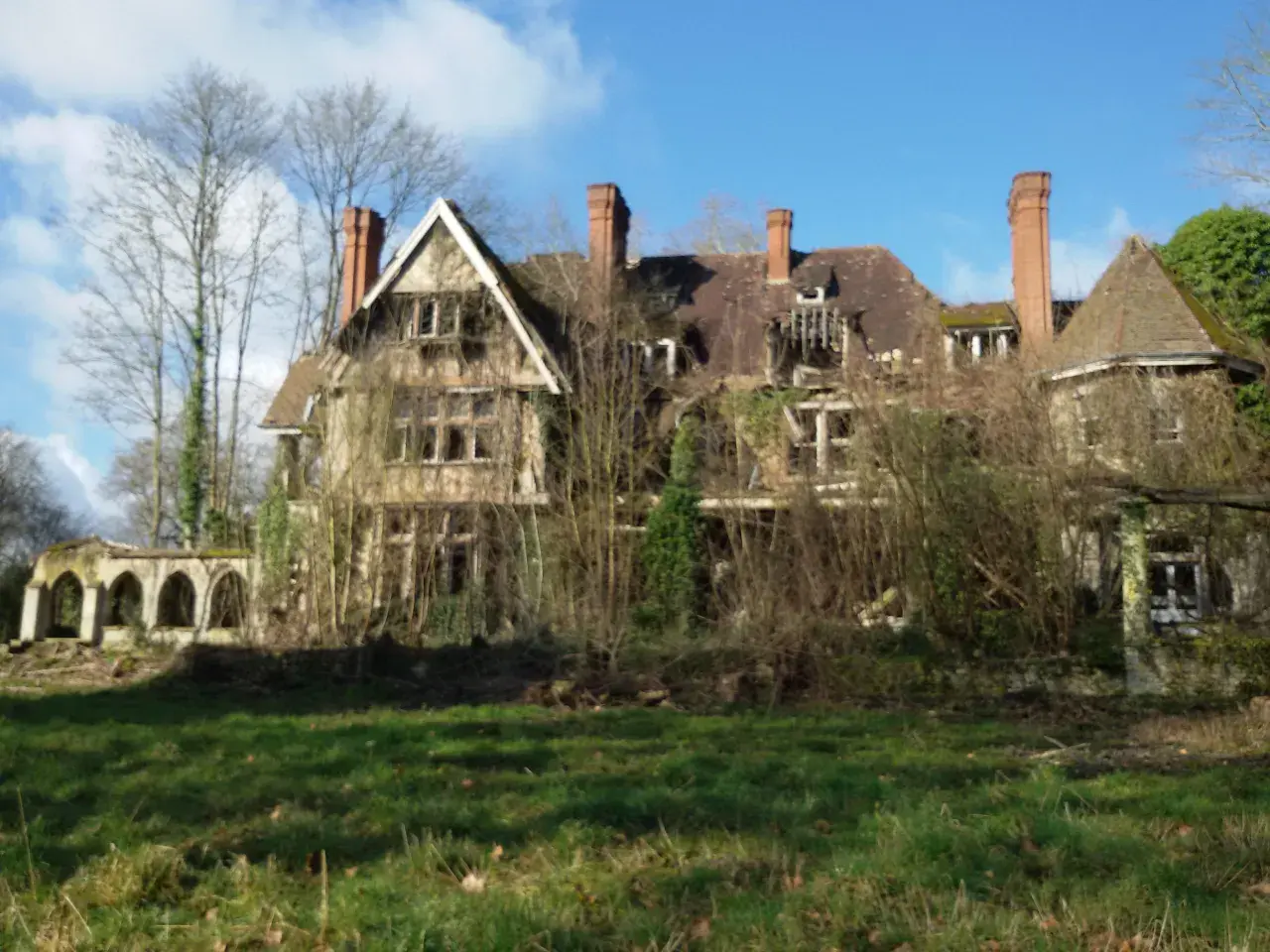 Maison abandonnée envahie par la végétation, un vestige de l'urbex Sarthe. Le toit est délabré, les fenêtres brisées, et la nature reprend ses droits.