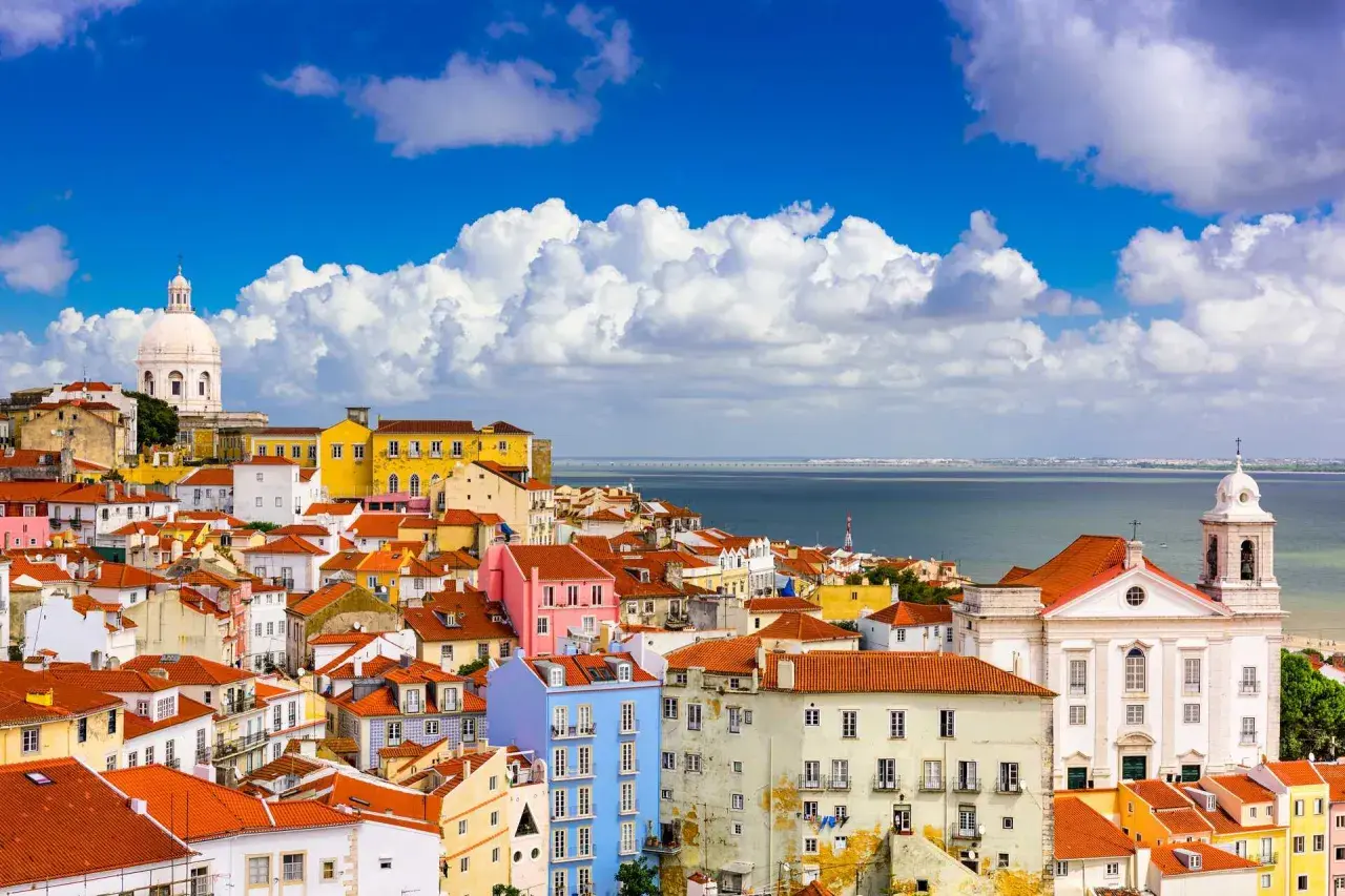 Färgglada hus i Lissabon under en blå himmel med moln. Perfekt lissabon temperatur för att utforska staden.