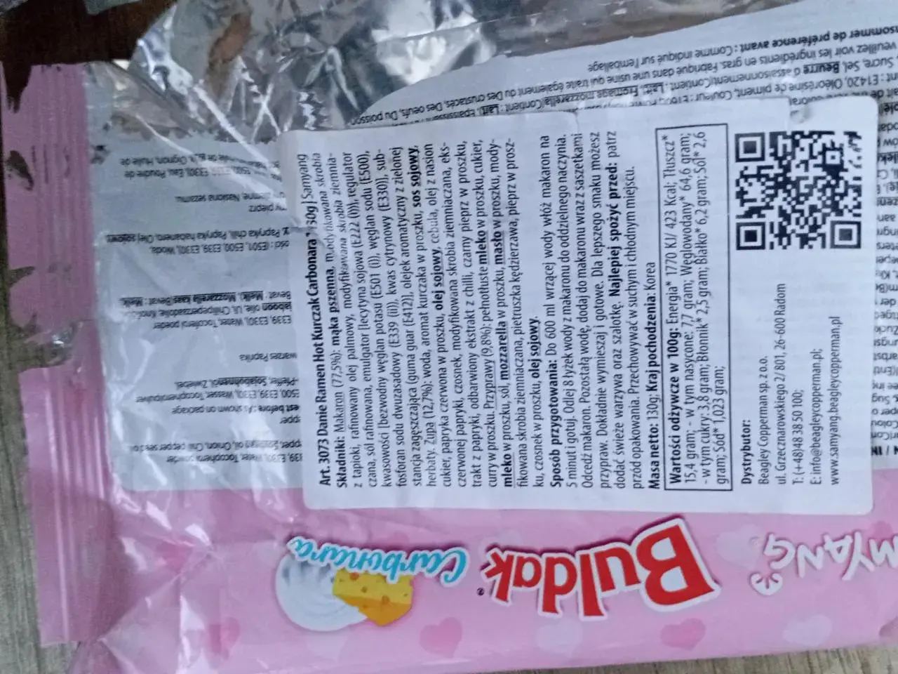 Buldak Carbonara ramen z makaronem i sosem. Wartość odżywcza na 100g: 1770 kJ/423 kcal. Tłuszcz: 15,4g.