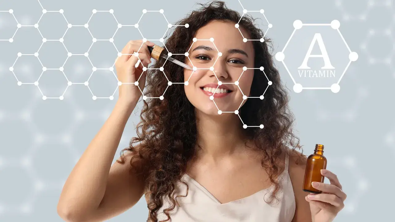 Kobieta z serum na twarzy, symbolizującym, jak działa retinol. W tle grafika przedstawiająca cząsteczki i witaminę A.