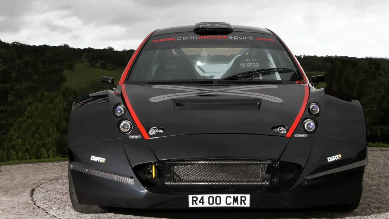 Schwarzer Rallye-Rennwagen, ein Colin McRae R4, mit roten Akzenten und dem Schriftzug "www.colinmcraesport.com" auf der Windschutzscheibe.