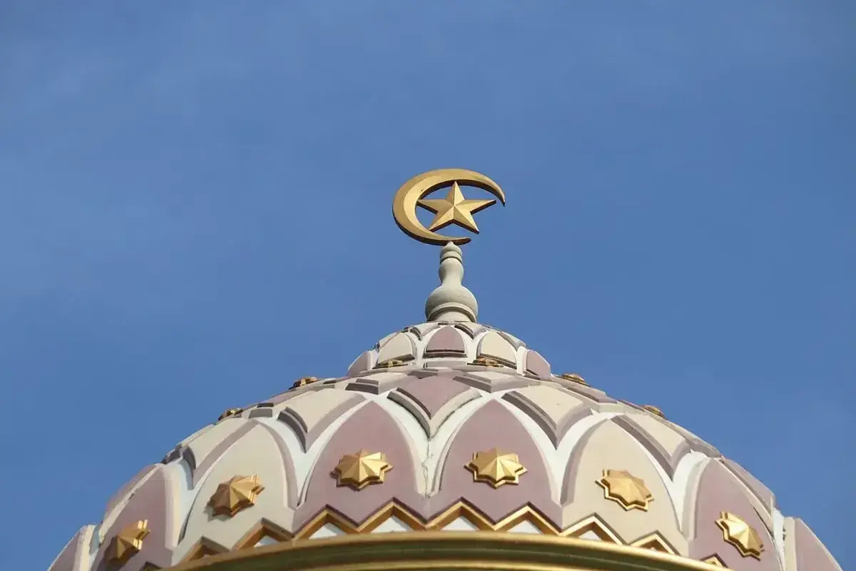 Złoty półksiężyc z gwiazdą na szczycie kopuły meczetu, symbol wiary. Bismillah.
