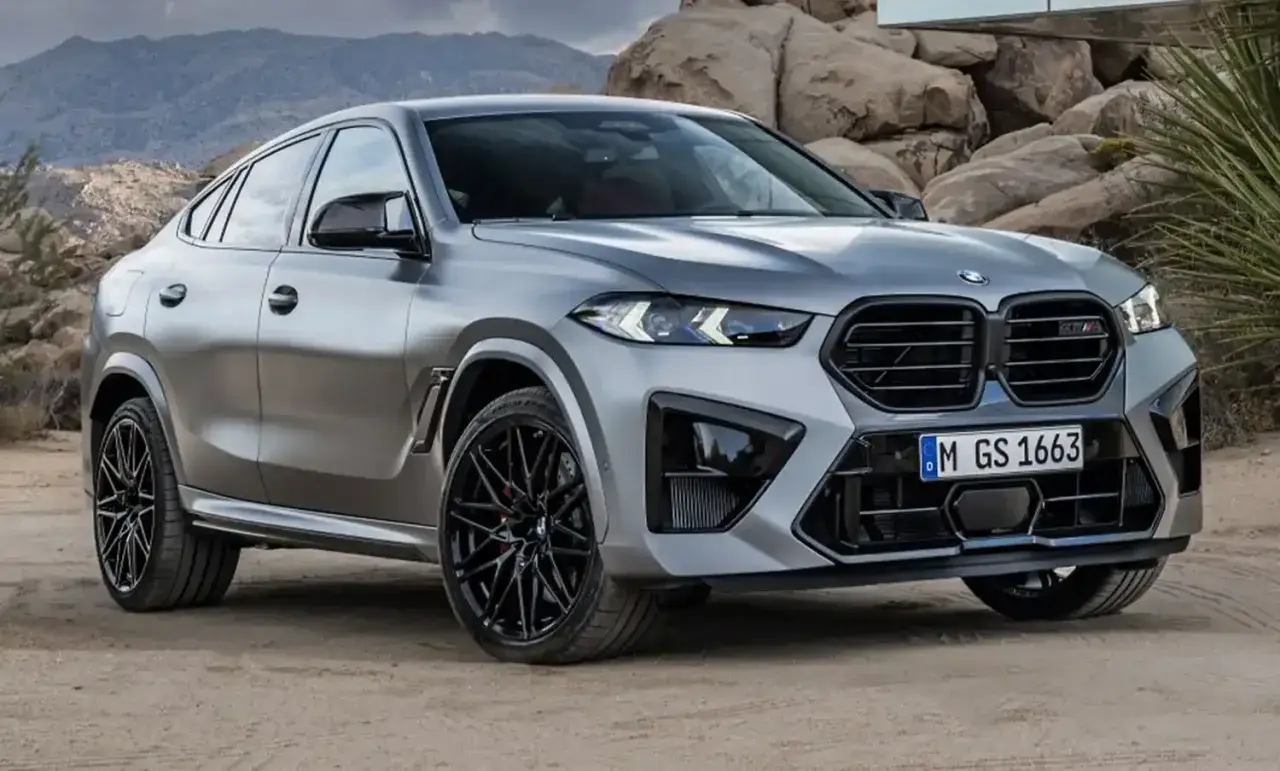 Srebrne x6 BMW z czarnymi felgami na tle skalistego krajobrazu.