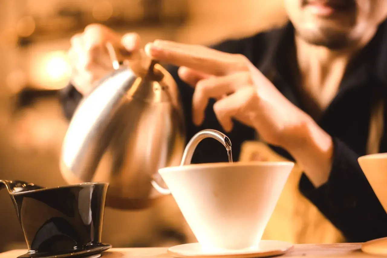 Barista häller upp varmt vatten för kaffe. Undrar hur hårt vatten har jag för att få bästa smak?