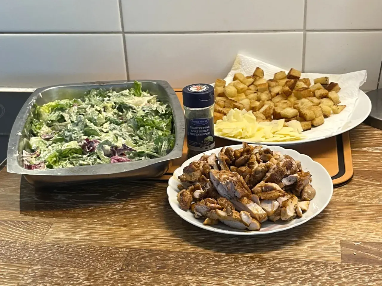 Förberedelser för ett fantastiskt ceasarsallad recept: krispig sallad, stekt kyckling, krutonger och parmesan.