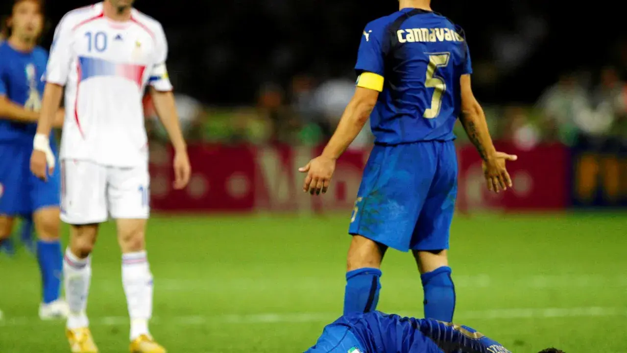 Zidane leży na ziemi po starciu z Materazzim. W tle widać innych piłkarzy.