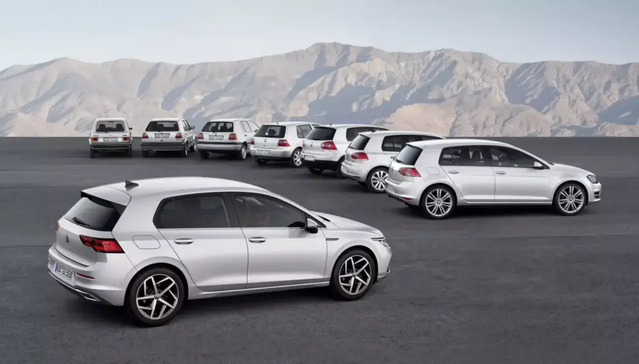 Ewolucja modelu golf 9. Rząd srebrnych samochodów, od klasycznych po nowoczesne, na tle gór.