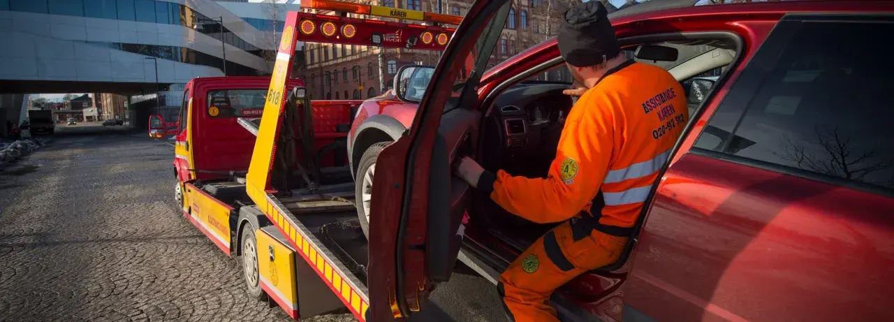 Bärgare hjälper en förare vars dieselbil fått bensin. Bilen lastas på en bärgningsbil.