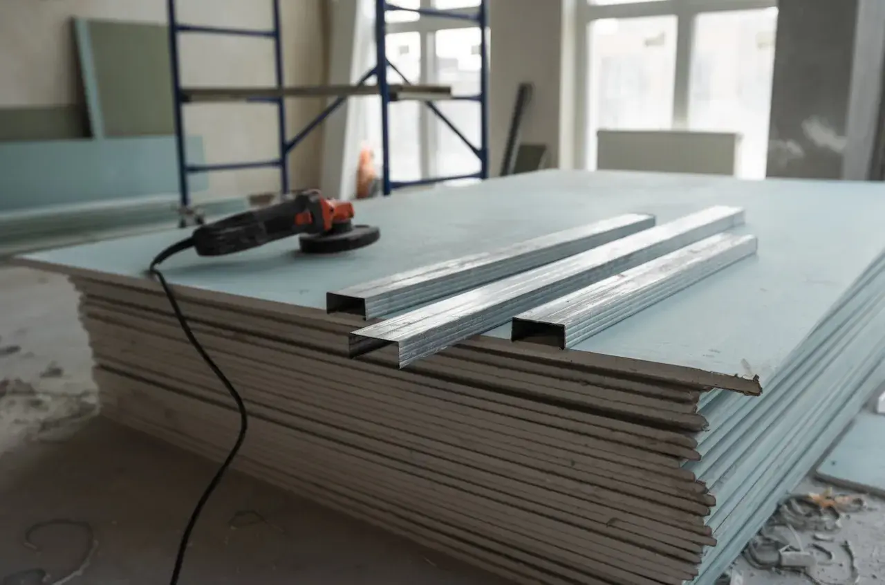 Materiali per un tutorial cartongesso: lastre, profili metallici e smerigliatrice.