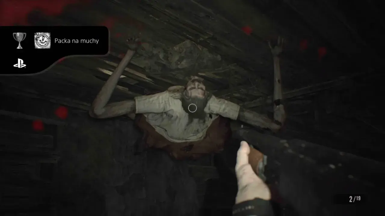 Zdobądź osiągnięcie "Packa na muchy" w Resident Evil 7. Potwór wisi na suficie, a gracz celuje bronią.