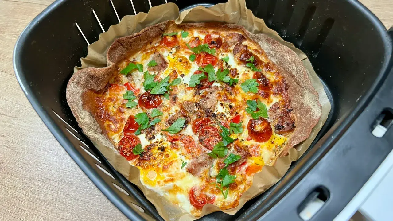 Pyszna tortilla z airfryer, z pomidorkami, serem i ziołami, gotowa do podania.