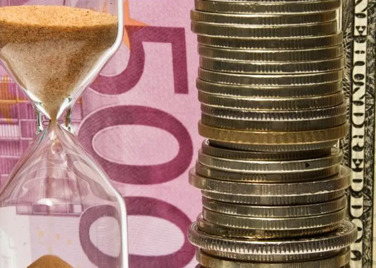 Klepsydra i stos monet na tle banknotu 500 euro. Czy numizmaty co to, to tylko monety?