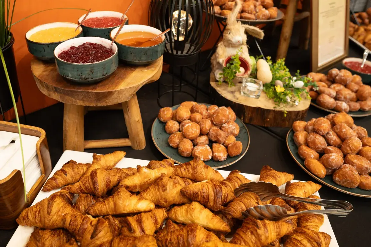 Bufet finger food: świeże rogaliki, pączki i miseczki z dżemami. Idealna uczta dla każdego.