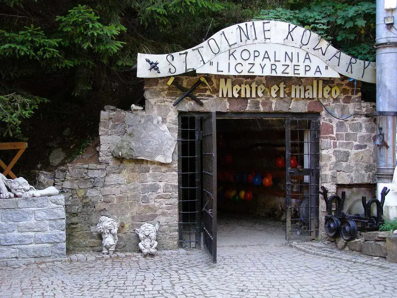 Kowary atrakcje: wejście do Sztolni Liczyrzepa, kamienne krasnale i kamienne rzeźby.