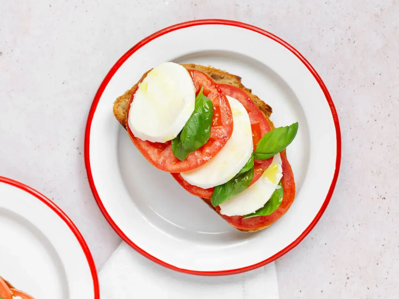 Tosta con tomate, mozzarella fresca y albahaca, inspirada en la ensalada caprese.