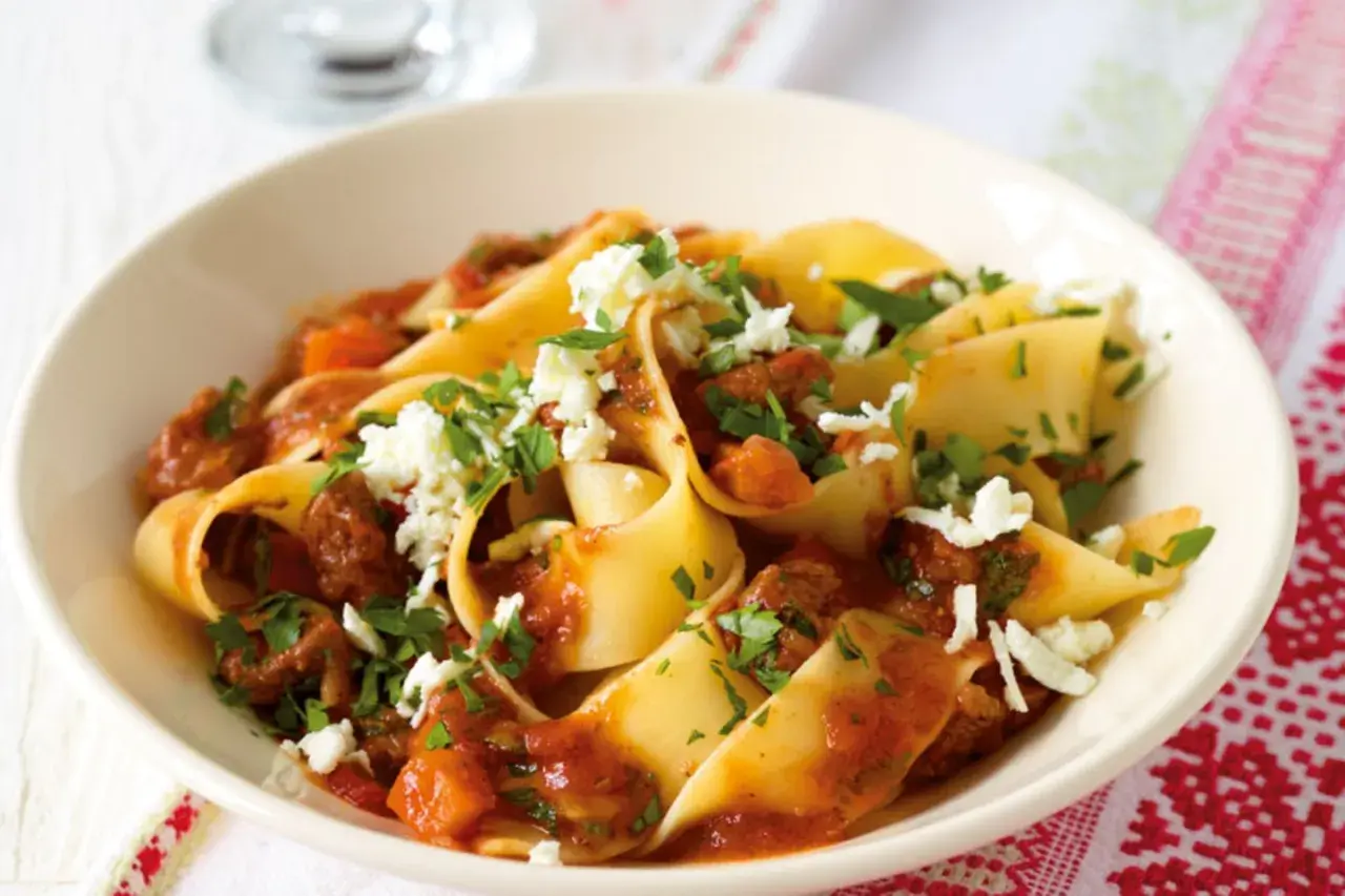 Breite Bandnudeln mit einer herzhaften Rinderhackfleischsauce und zerbröseltem Käse, ein klassisches italienisches Gericht.