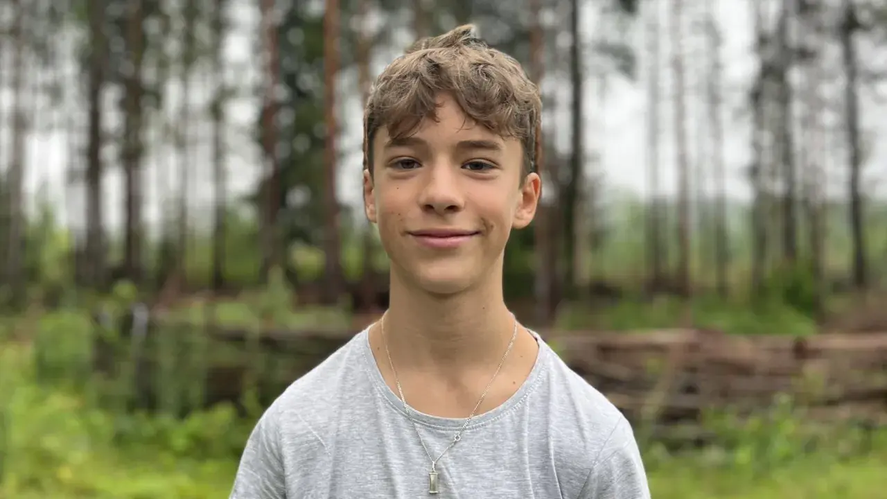 En leende Jack Bergnorth Henriksson står framför en skog.