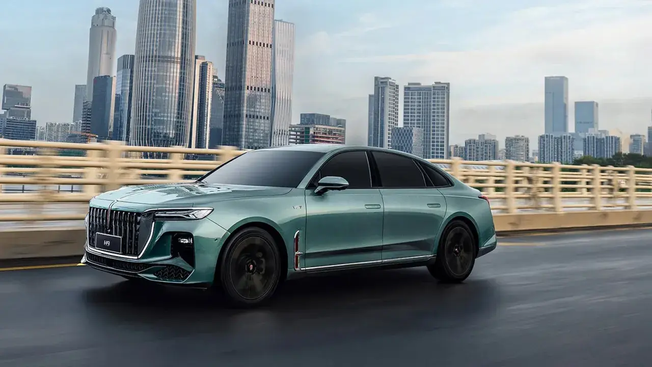 Elegancki, zielony Hongqi H9 na tle drapaczy chmur. Sprawdź, jaka jest jego hongqi h9 cena i poczuj luksus.