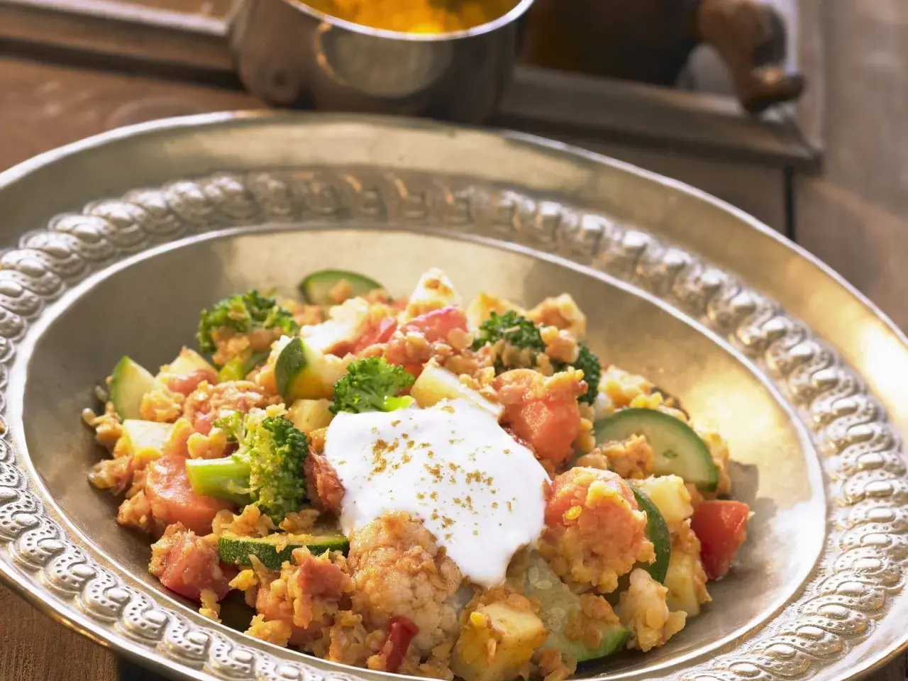 Herzhaftes Linsengericht mit Brokkoli, Zucchini und Tomaten, garniert mit einem Klecks Joghurt. Ein köstliches Beispiel für Linsen Rezepte.