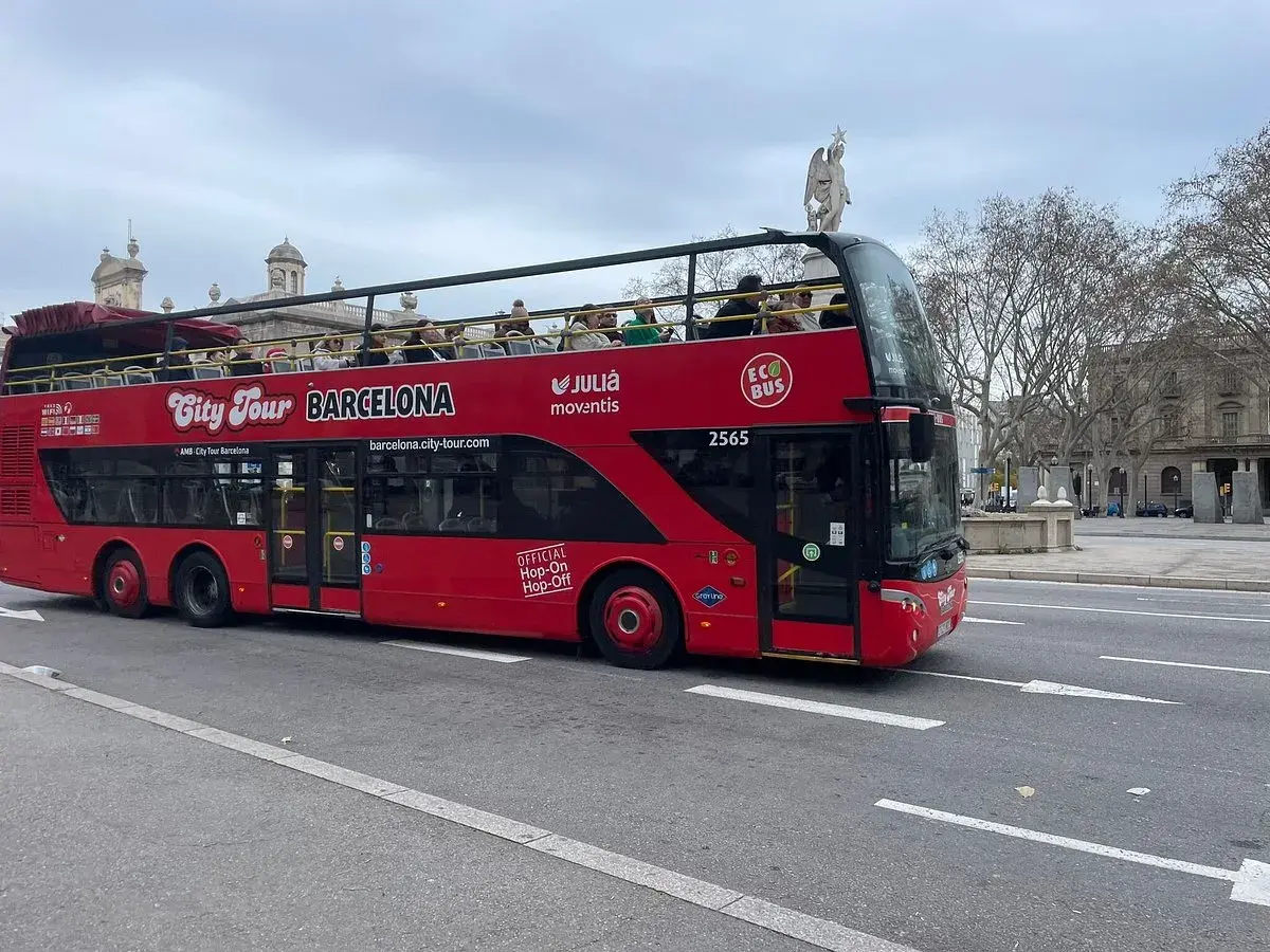 Roter Doppeldeckerbus für Barcelona Hop-On Hop-Off Touren fährt auf der Straße. Touristen genießen die Aussicht von oben.