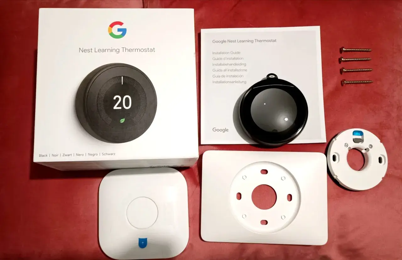 Kit pour l'installation d'un thermostat Nest Learning. Boîte, manuel, thermostat, socle et vis.