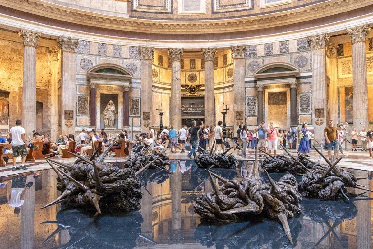 Intérieur du Panthéon de Rome, avec des sculptures modernes sur l'eau reflétant l'architecture antique.