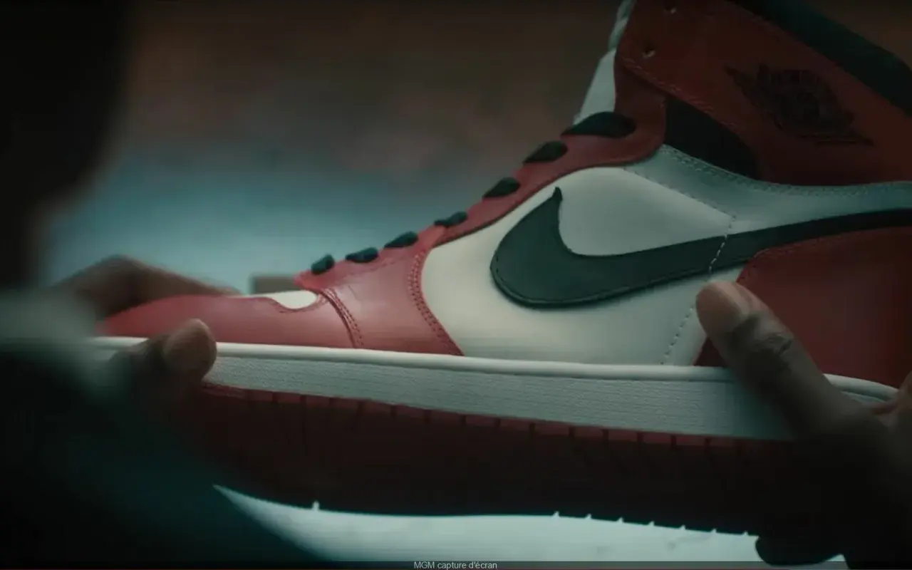 Dłonie trzymają kultowe czerwono-białe buty Air Jordan 1. Ten się śmieje, kto ma zęby, a te buty to marzenie wielu.