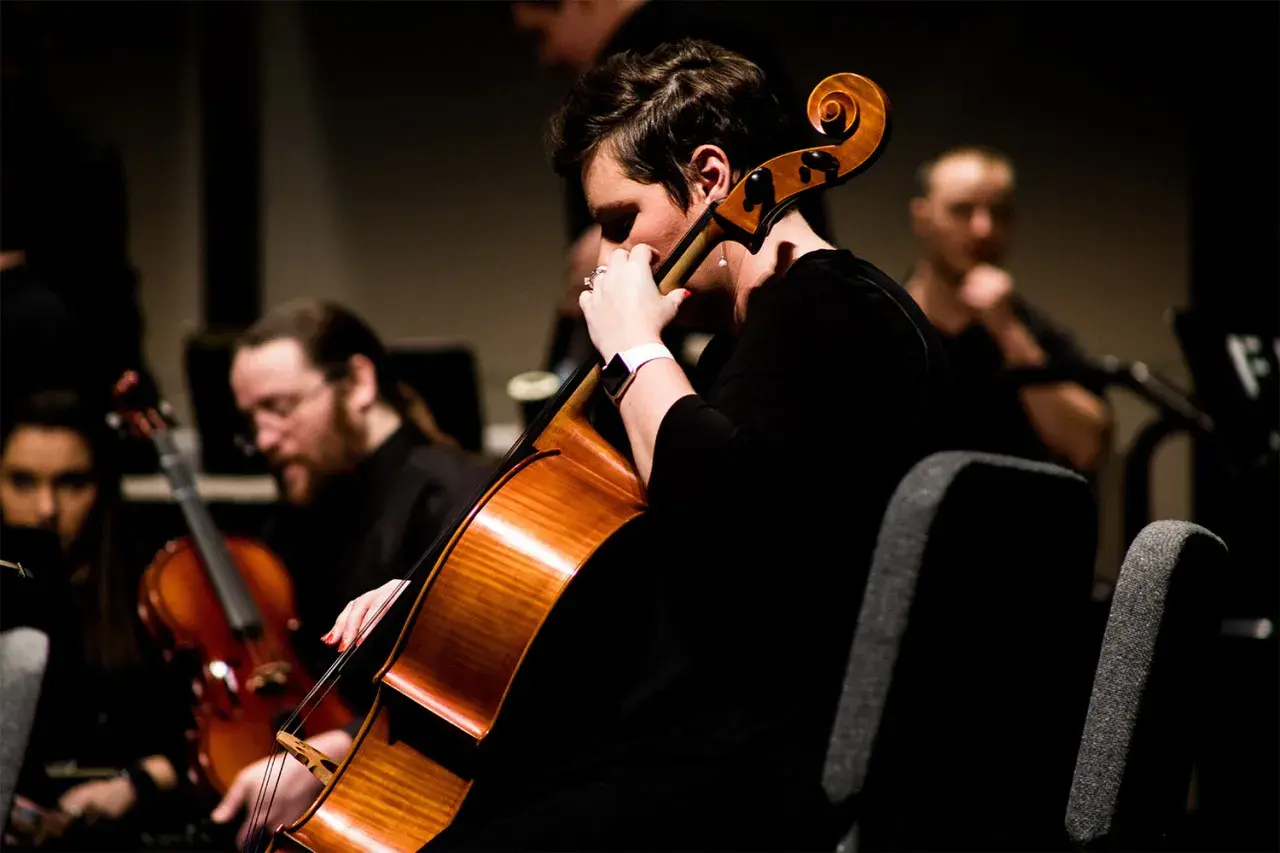 Une musicienne joue du contrebasse dans un orchestre.