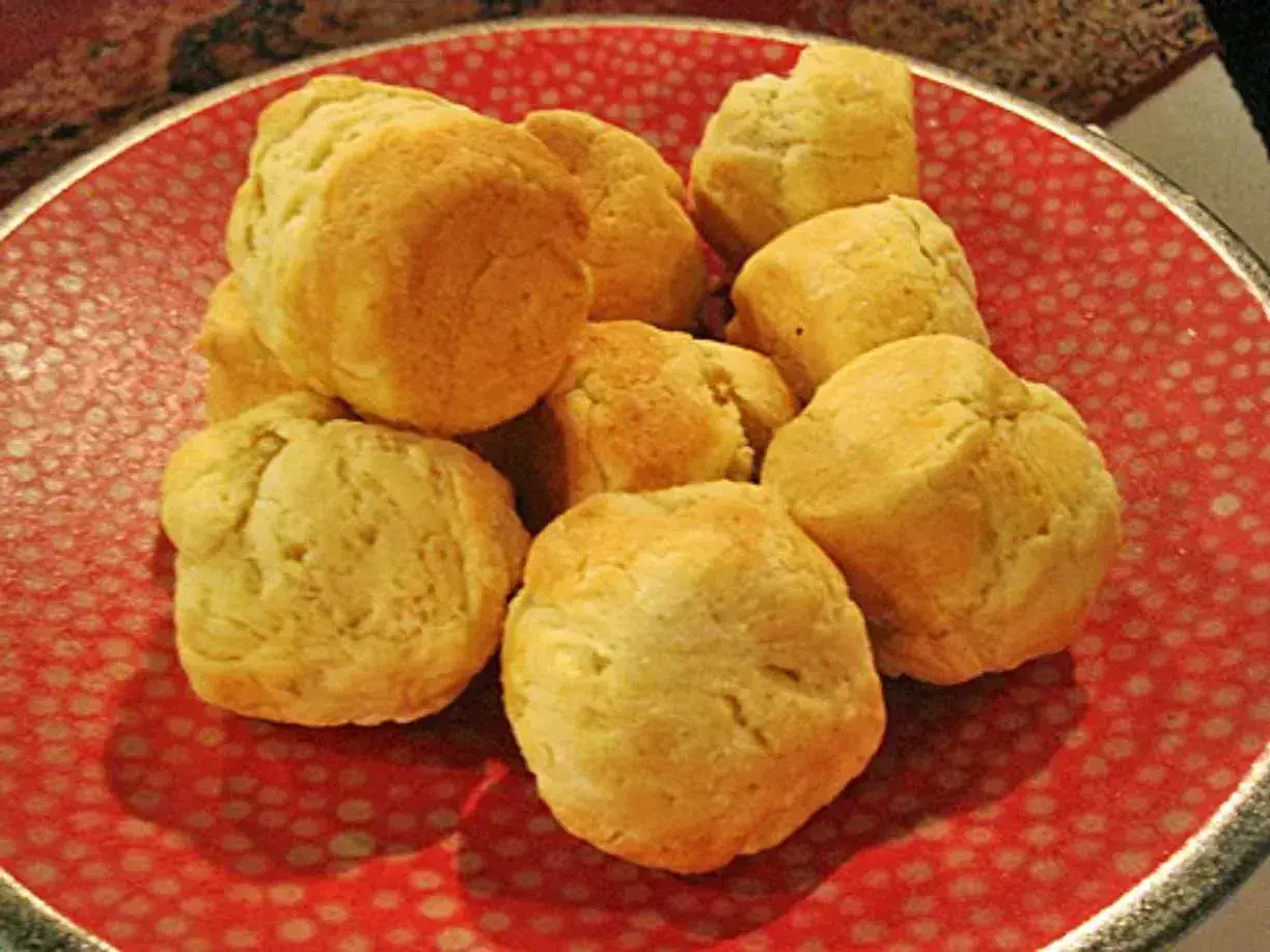 En hög med nybakade scones på en röd tallrik. Perfekt för ett mysigt fika med detta scones recept.