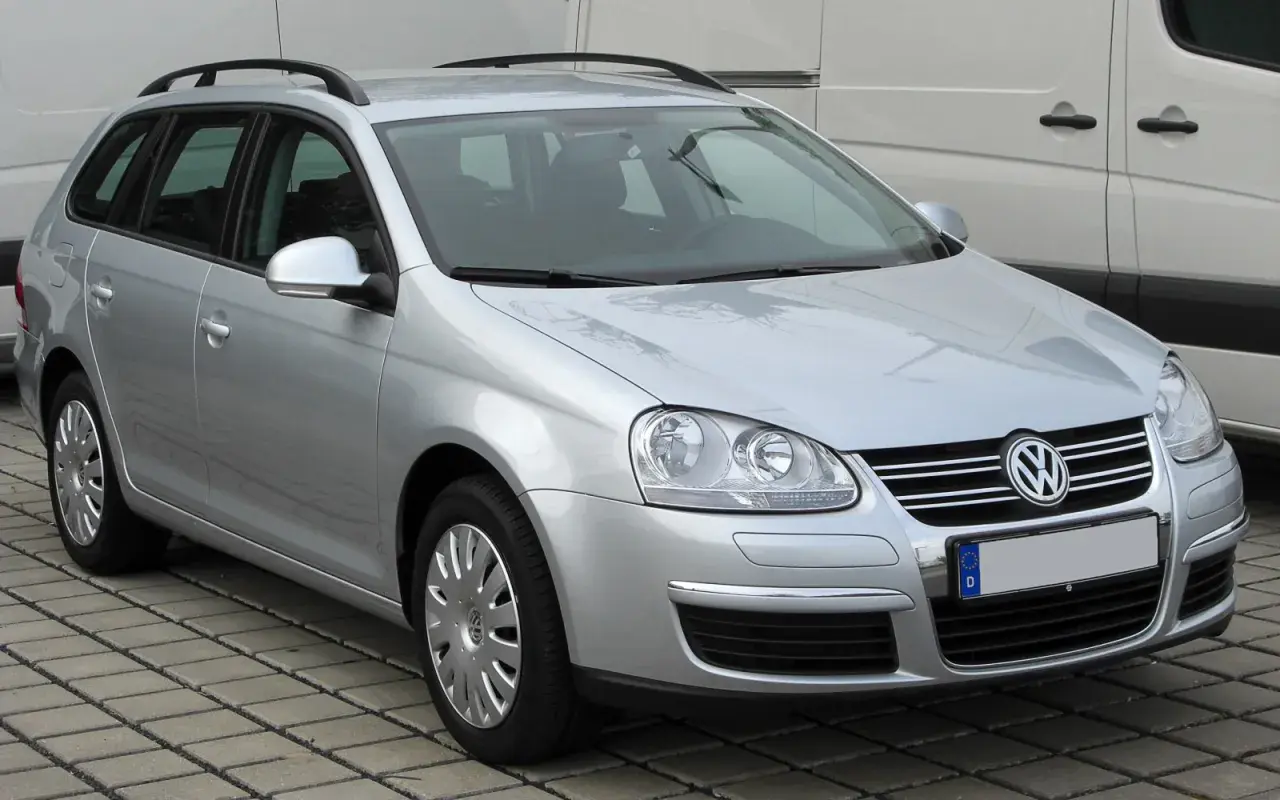 Srebrny Volkswagen Golf 5 Variant z relingami dachowymi, zaparkowany na kostce brukowej.