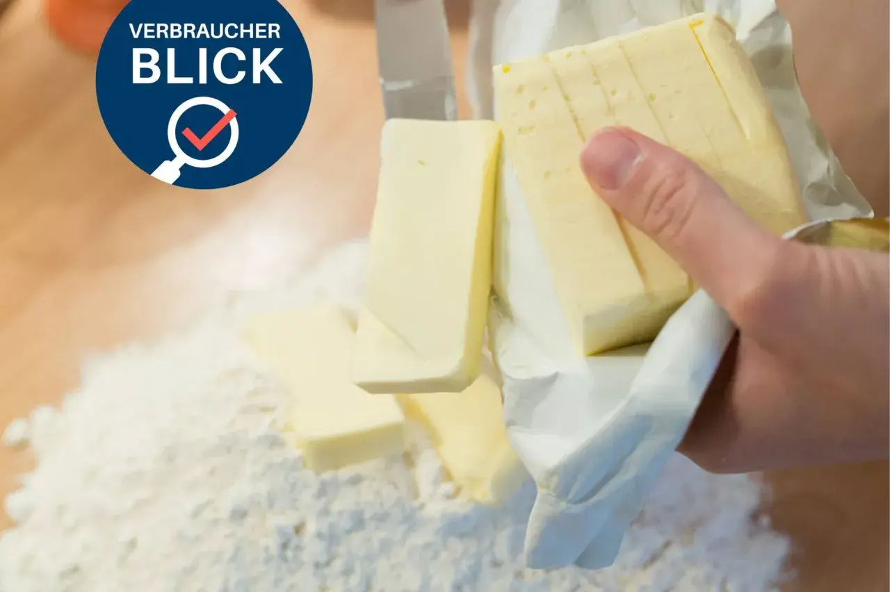 Verbraucherblick: Welche Butter ist die beste? Ein Messer schneidet Butter, die auf Mehl liegt.