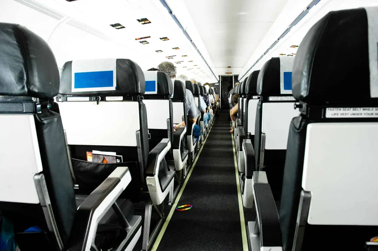 Blick in die Kabine eines Flugzeugs. Die Sitze sind in Reihen angeordnet. Die Frage, wo man im Flugzeug am besten sitzt, bleibt offen.