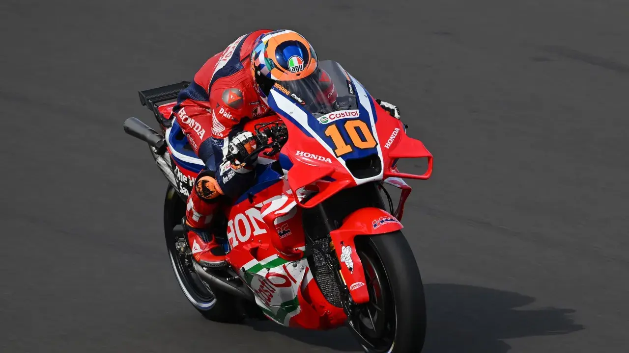 Luca Marini en su moto Honda número 10, con su traje rojo y azul, compite en la pista.