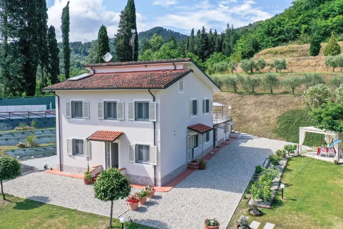 Villa unifamiliare immersa nel verde, con un ampio giardino, uliveto e vista collinare.