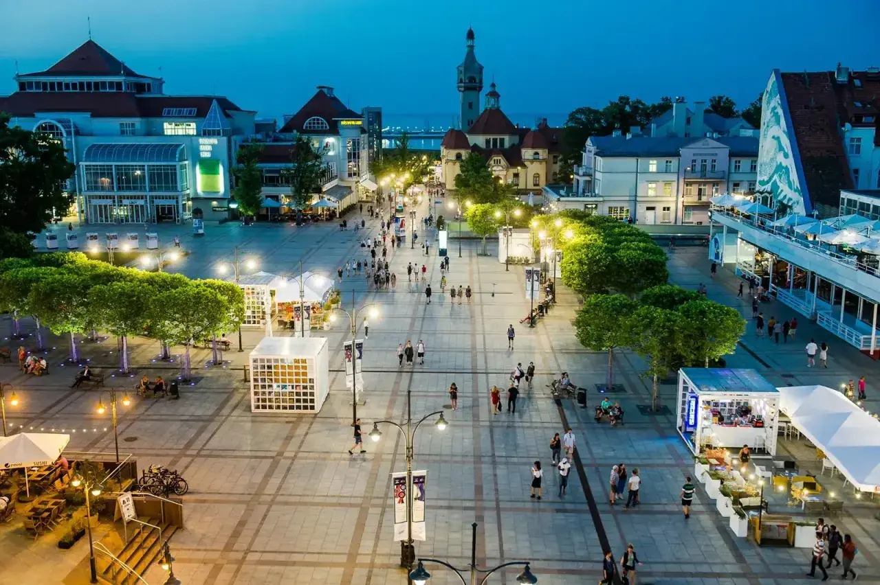Wieczorny spacer po sopockim deptaku, gdzie tętni życiem **Sopot stare miasto**. Ludzie przechadzają się wśród iluminacji, tworząc niepowtarzalny klimat.