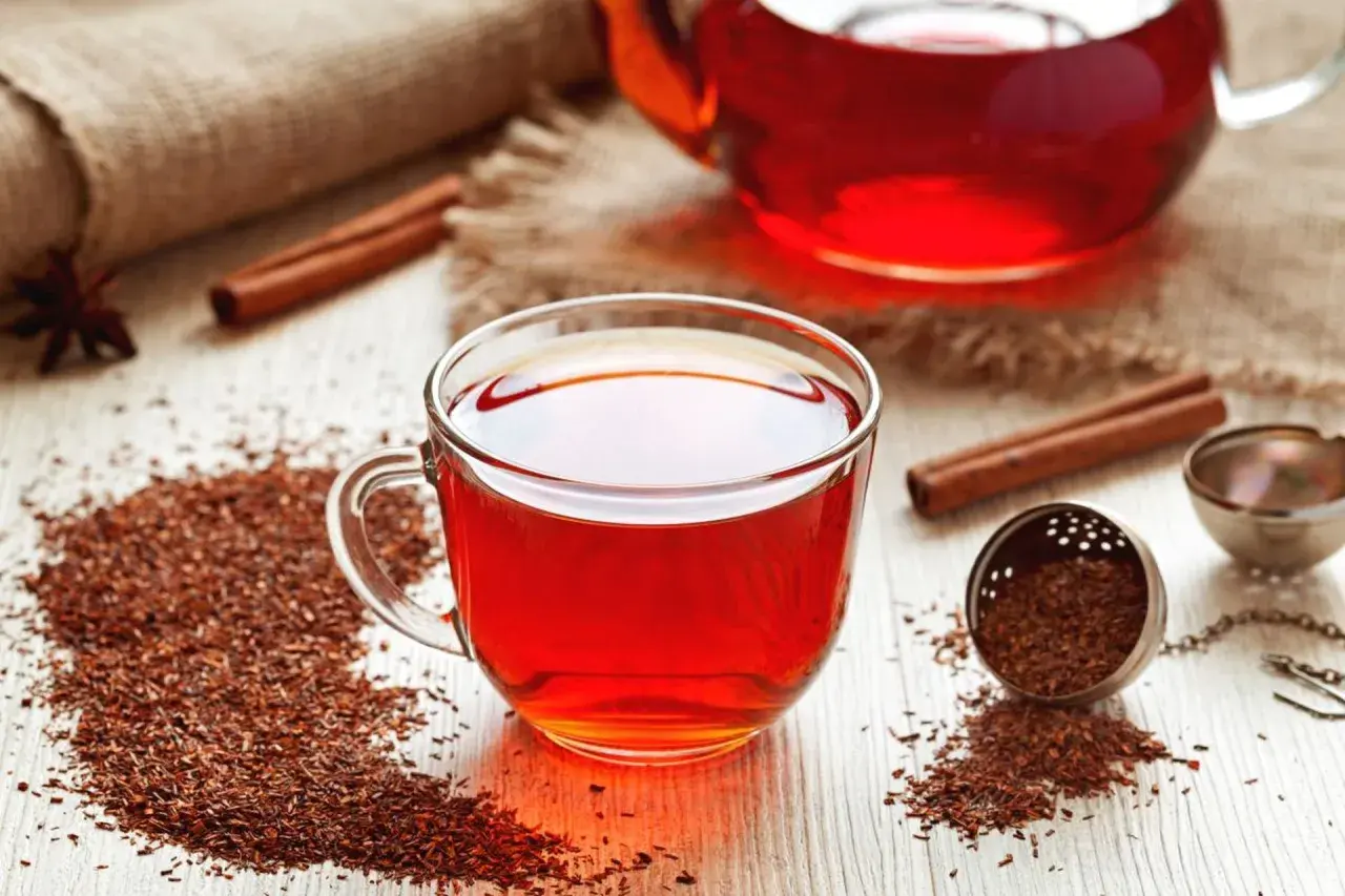 Aromatyczny rooibos zielony i czerwony w filiżance i dzbanku, z cynamonem i anyżem.